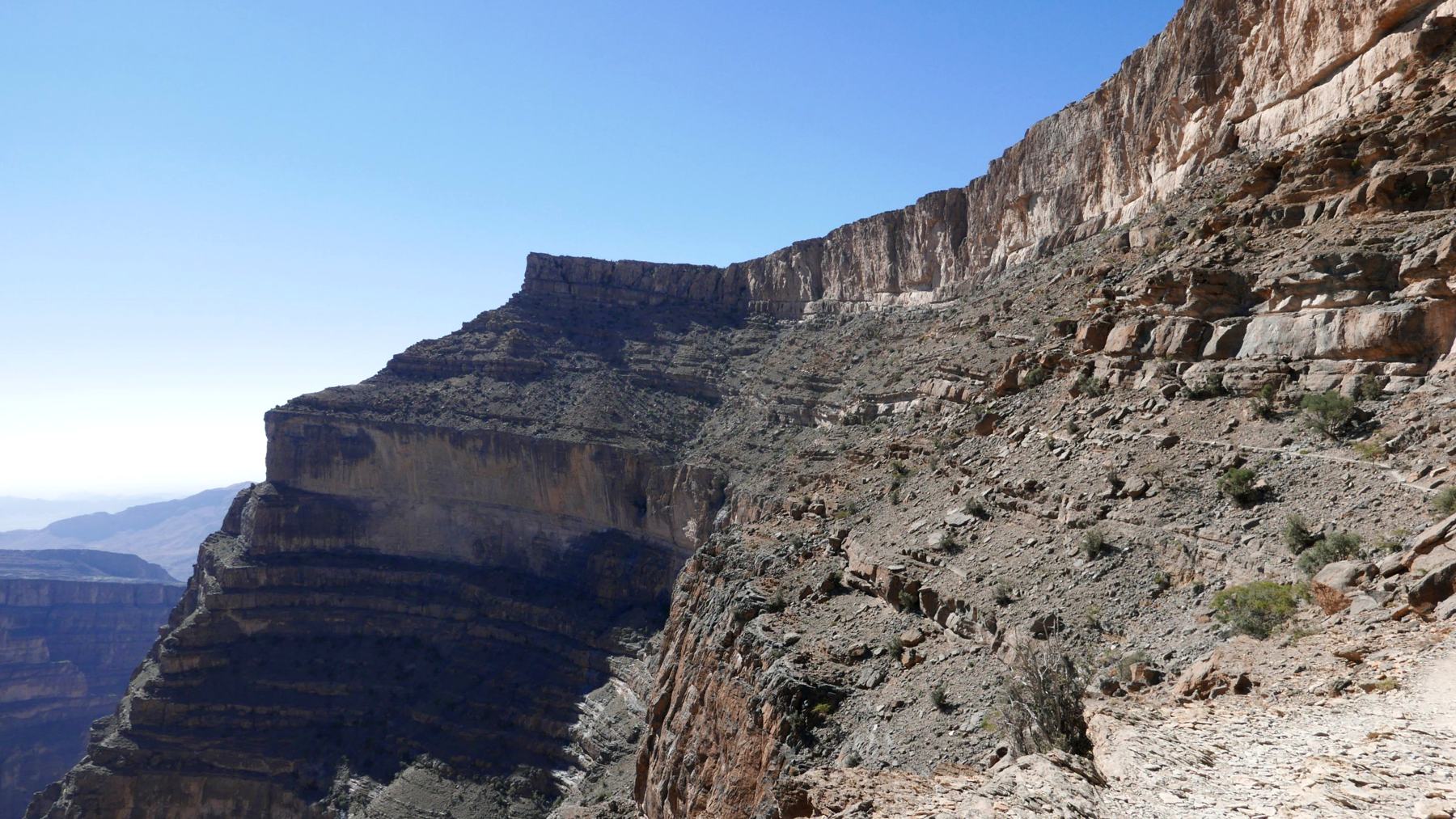 Il sentiero a strapiombo sul canyon di Jebel Shams, tra pareti di roccia stratificata