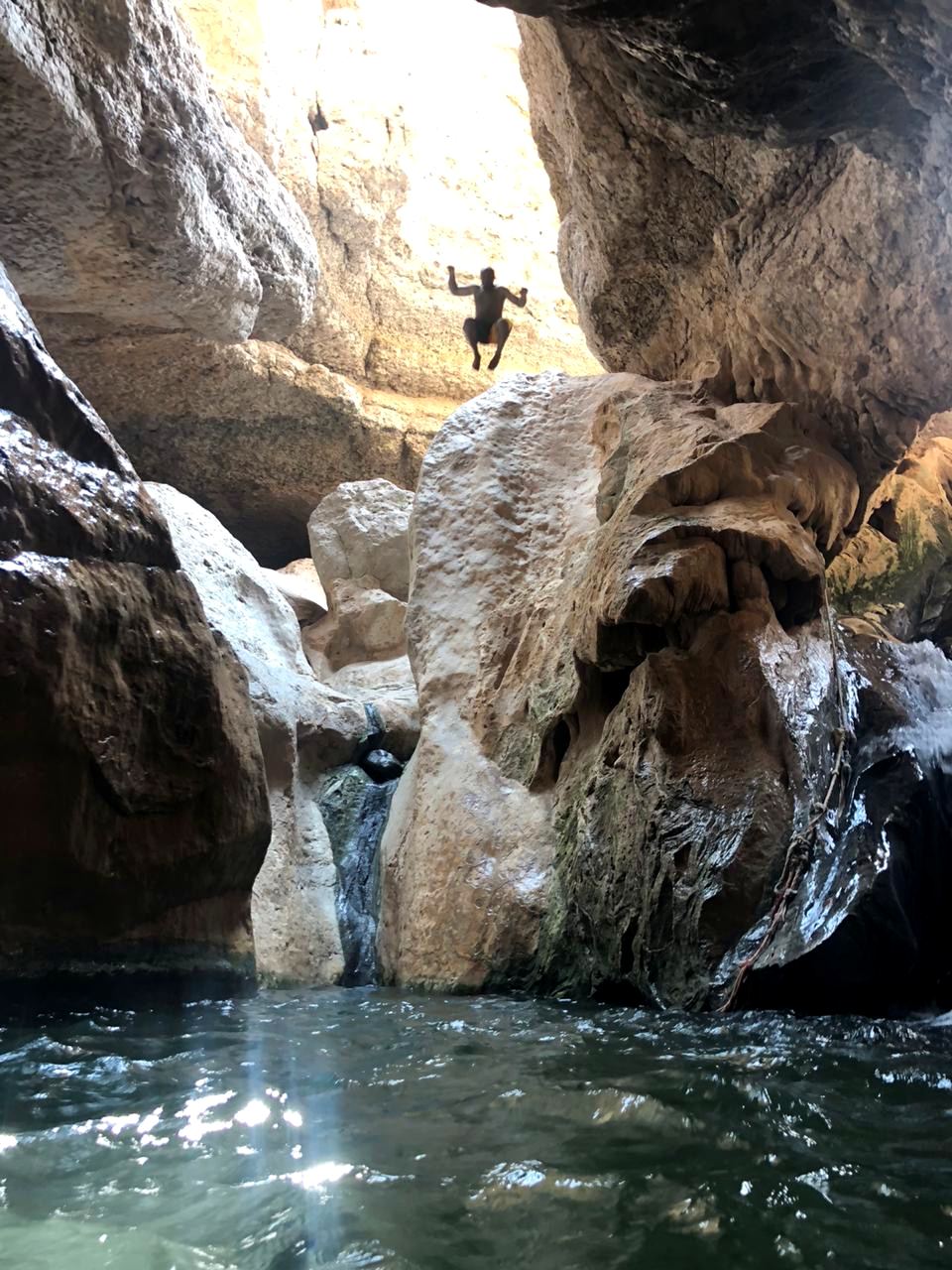 Un tuffo nella gola d'acqua di Wadi Shab, tra rocce levigate e una piccola cascata